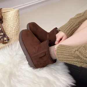 Primer plano de botas de nieve de cuero esmerilado marrón con forro cálido de invierno