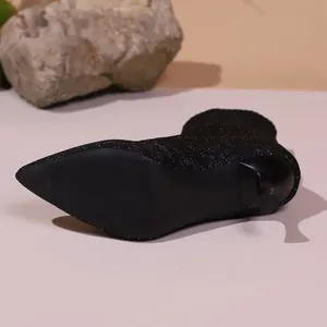 Nahaufnahme schwarzer Glitzer-Sockenstiefel mit spitzer Zehenpartie und Stöckelabsatz.