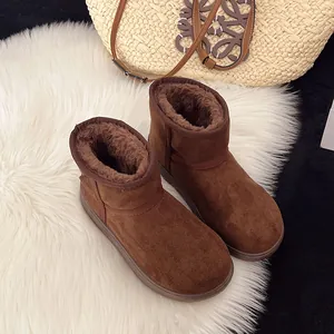 Detalle de botas de nieve de ante marrón cálido con forro de piel sintética gruesa