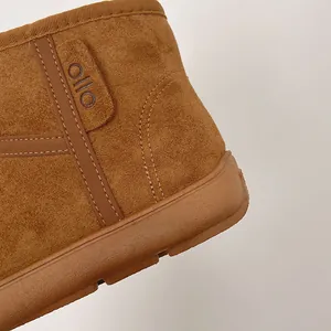 Primer plano de bota de nieve de cuero esmerilado marrón con finas costuras y logo