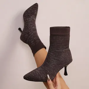 Nahaufnahme von braunen Glitzer-Strickstiefeln mit Pfennigabsatz und Spitze