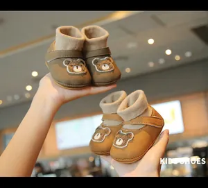 Detailed view of two pairs of cute bear baby winter walking shoes with fleece lining.