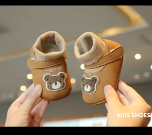 Close-up of brown baby walker shoes with cute bear patches and warm plush lining