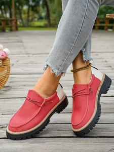 Modieuze rood-witte vintage canvas loafers voor dames met stevige zwarte profielzolen.