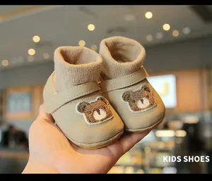 Detailed view of warm winter baby walker shoes with cute bear embroidery pattern.