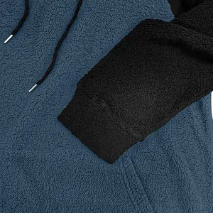 Makroansicht der weichen Fleece-Struktur und des Rippbündchens eines Herren-Kapuzenpullovers.