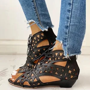 Close-up of black cutout lace-up wedge sandals with peep-toe and back zipper detail