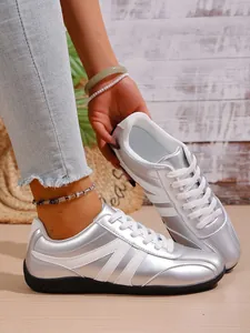 Metallic silver German training sneakers with breathable mesh lining and white laces.
