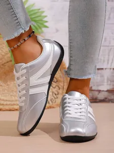 Stylish silver metallic sneakers for women with white decorative stripes
