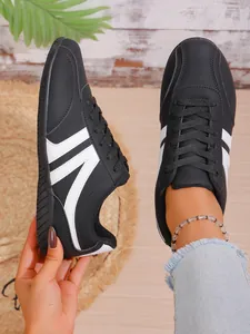 Black and white casual sneakers for women, showing lightweight design and side stripes