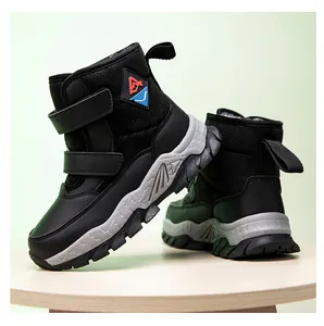Detail side view of black boys high-top snow boots with Velcro straps and thick soles