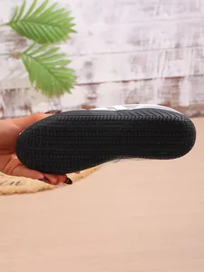 Close-up of the non-slip rubber sole with tire tread pattern on a white sneaker.