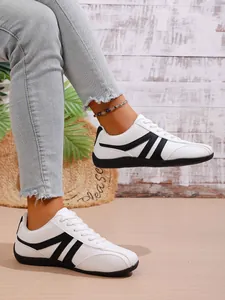 Detailed side view of white German Army Trainers with black stripe accents for women