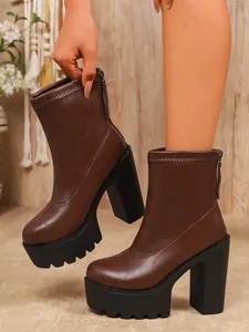 Close-up of brown platform ankle boots with chunky high heels and lug soles