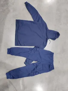 Volledig overzicht van marineblauw zwaar fleece trainingspak op een gestructureerde vloer