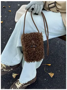 Close-up of a vintage brown fuzzy small shoulder bag with a leather strap and toggle button.