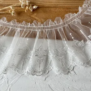 Close-up view of delicate white butterfly embroidered tulle lace trim with wavy edges