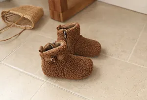Close-up of brown fuzzy kids snow boots with warm fleece lining and side zipper