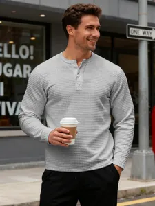 Close-up of a grey long-sleeve Henley shirt with a waffle texture on a male model.