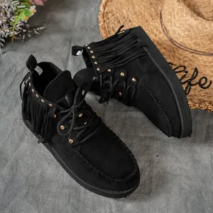 Detailed view of black suede fringe boots with gold studs in Western cowboy style