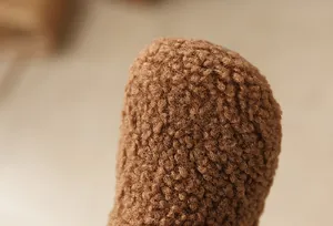 Close-up macro detail of soft brown teddy fleece texture on warm winter snow boots for girls.