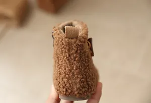 Close-up of the fuzzy brown texture and heel strap of girls' winter snow boots