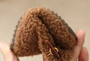 Detail of flexible sole and warm fleece lining on girls' brown snow boots