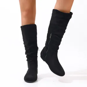 Close-up detail of black suede slouchy tall boots featuring functional side zipper