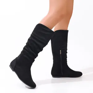 Side view of stylish black slouchy flat mid-calf boots with a functional side zipper