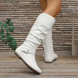 Detail view of white slouchy high-top knight boots with flat soles and side buckle.