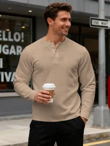 Detailed view of men's khaki waffle-knit Henley shirt with long sleeves and textured fabric