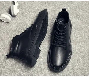 Vue détaillée des bottines Martin en cuir noir pour hommes sur fond de tapis gris texturé.