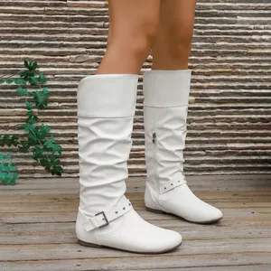 Detail of white flat knee-high slouchy boots with stylish buckle and rivet accents