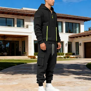 Vue complète du survêtement cargo noir pour homme avec accents vert néon devant villa
