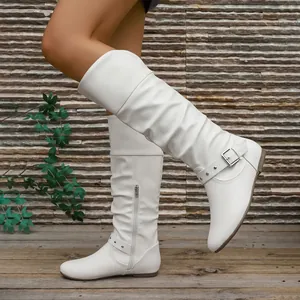 Side view of white slouchy high-top flat knight boots with buckle and silver rivets