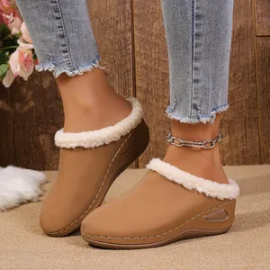 Detail view of women's tan fur-lined wedge clogs worn with jeans on a soft rug.