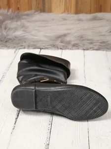 Macro view of the durable non-slip sole and decorative side buckle on a black boot
