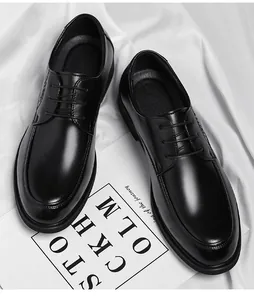 High-angle shot of elegant black leather men's dress shoes presented on white fabric