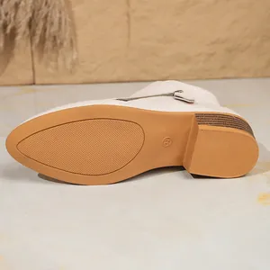 Detail van de duurzame antislip rubberen zool op een beige enkellaars voor dames