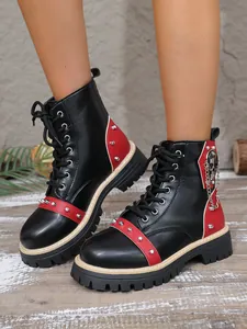 Détail de bottines à plateforme noires avec rivets rouges et chaîne tête de mort