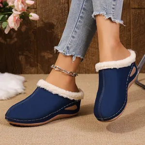 Close-up of women's dark blue wedge slippers with white plush lining worn at home