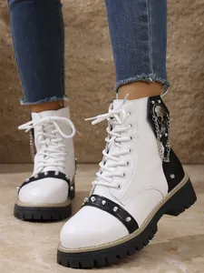 Gros plan de bottines à plateforme blanches avec breloque crâne et rivets en métal