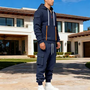 Survêtement homme en polaire lourde bleu marine avec touches orange devant villa de luxe
