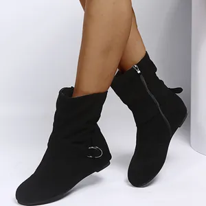 Close-up of black suede vintage boots with buckle and zipper detail for women