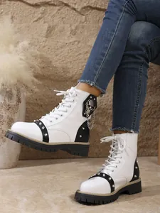 Détail de bottines à plateforme blanches avec clous argentés et décor de crâne