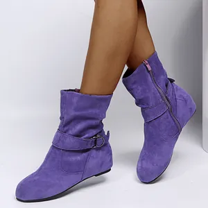 Detail shot of purple suede women's ankle boots with decorative buckle and side zip.