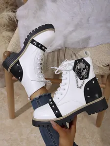 Vue détaillée des bottines à plateforme blanches avec emblème de crâne et clous