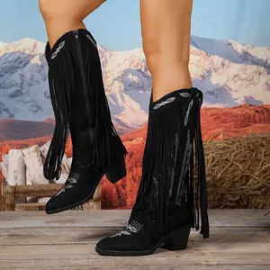 Detail von schwarzen Vintage-Cowboy-Stiefeln mit Silberstickerei und langen Fransen.