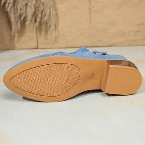 Detailopname van de antislip bruine rubberen zool van een blauwe denim damesschoen.
