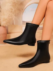Detailansicht der stilvollen schwarzen Stiefeletten mit spitzer Kappe und Reißverschluss
